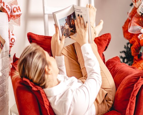 Mature adult enjoying a book in a comfortable sunlit armchair